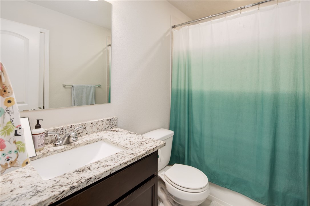 2120 Markley Drive Bryan, TX 77807 - Photo 15 of 21 a bathroom with a granite countertop sink a toilet and shower
