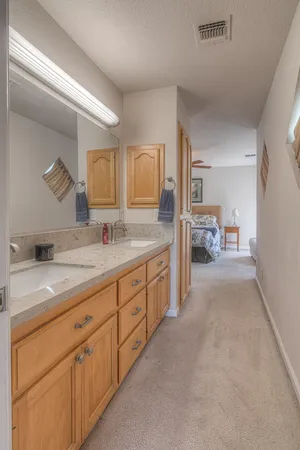 a spacious en suite bathroom with double sink and a mirror