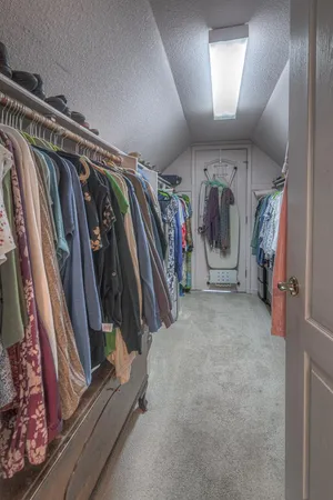a view of walk in closet with clothes and shoes