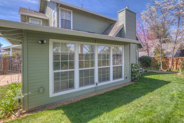 a view of a house with a large window and plants