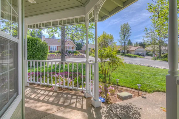 a view of a porch with a floor to ceiling window and wooden fence