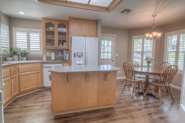a dining room with wooden floor and large windows