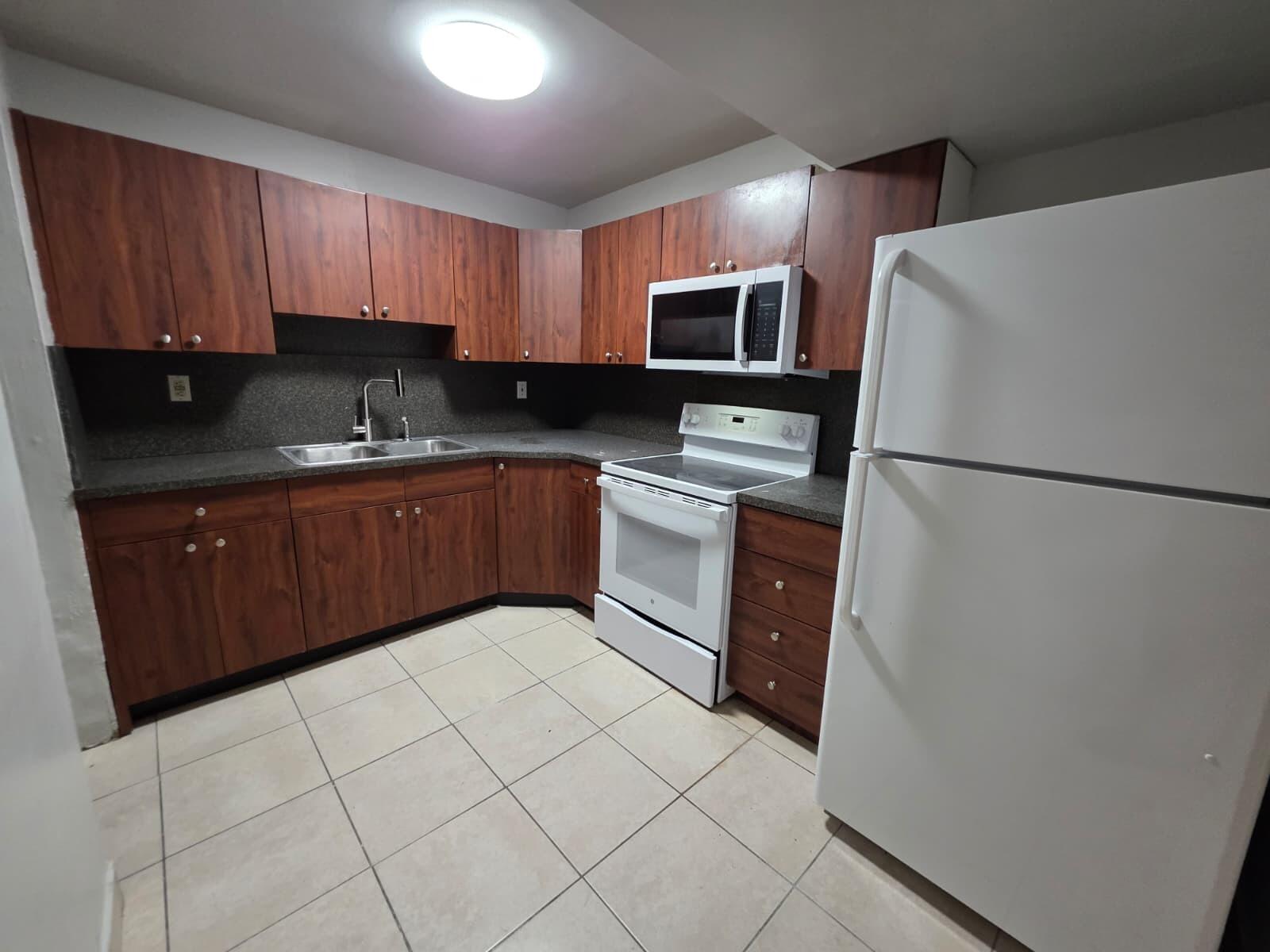 2767 Northwest 58th Terrace Lauderhill, FL 33313 - Photo 4 of 8 a kitchen with stainless steel appliances granite countertop a refrigerator stove a sink and dishwasher