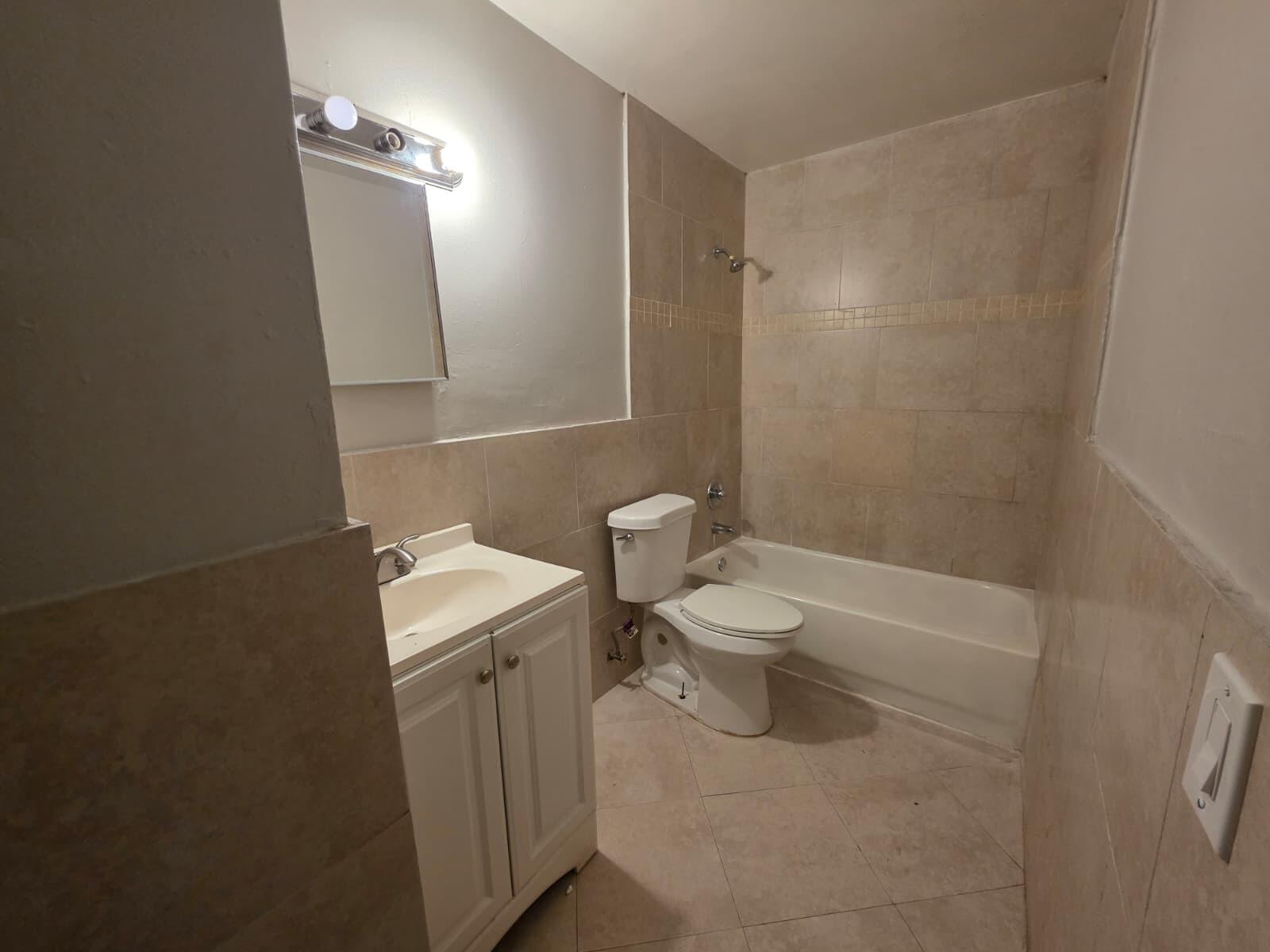 2767 Northwest 58th Terrace Lauderhill, FL 33313 - Photo 7 of 8 a bathroom with a toilet a sink and bathtub