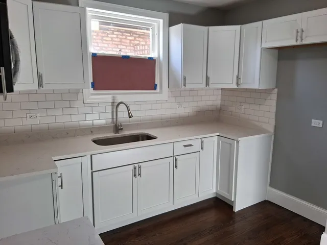a kitchen with a sink cabinets and a window