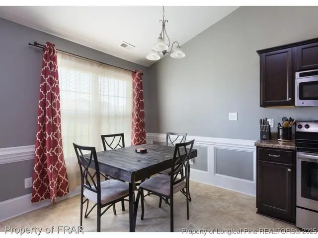 a view of a dining room with furniture and chandelier
