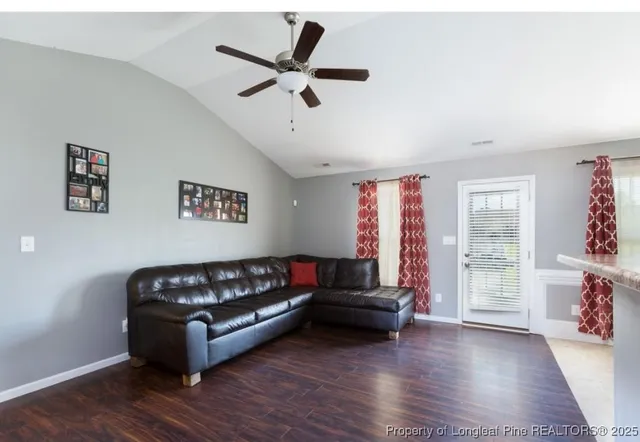 a living room with furniture and a wooden floor
