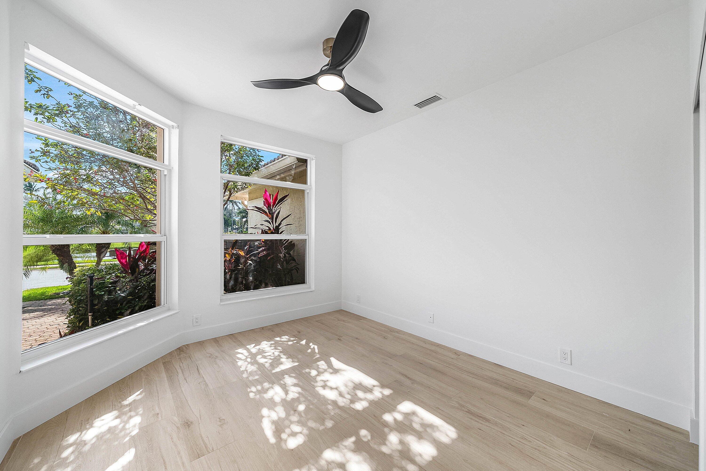 5174 Windsor Parke Drive Boca Raton, FL 33496 - Photo 17 of 55 an empty room with wooden floor and windows