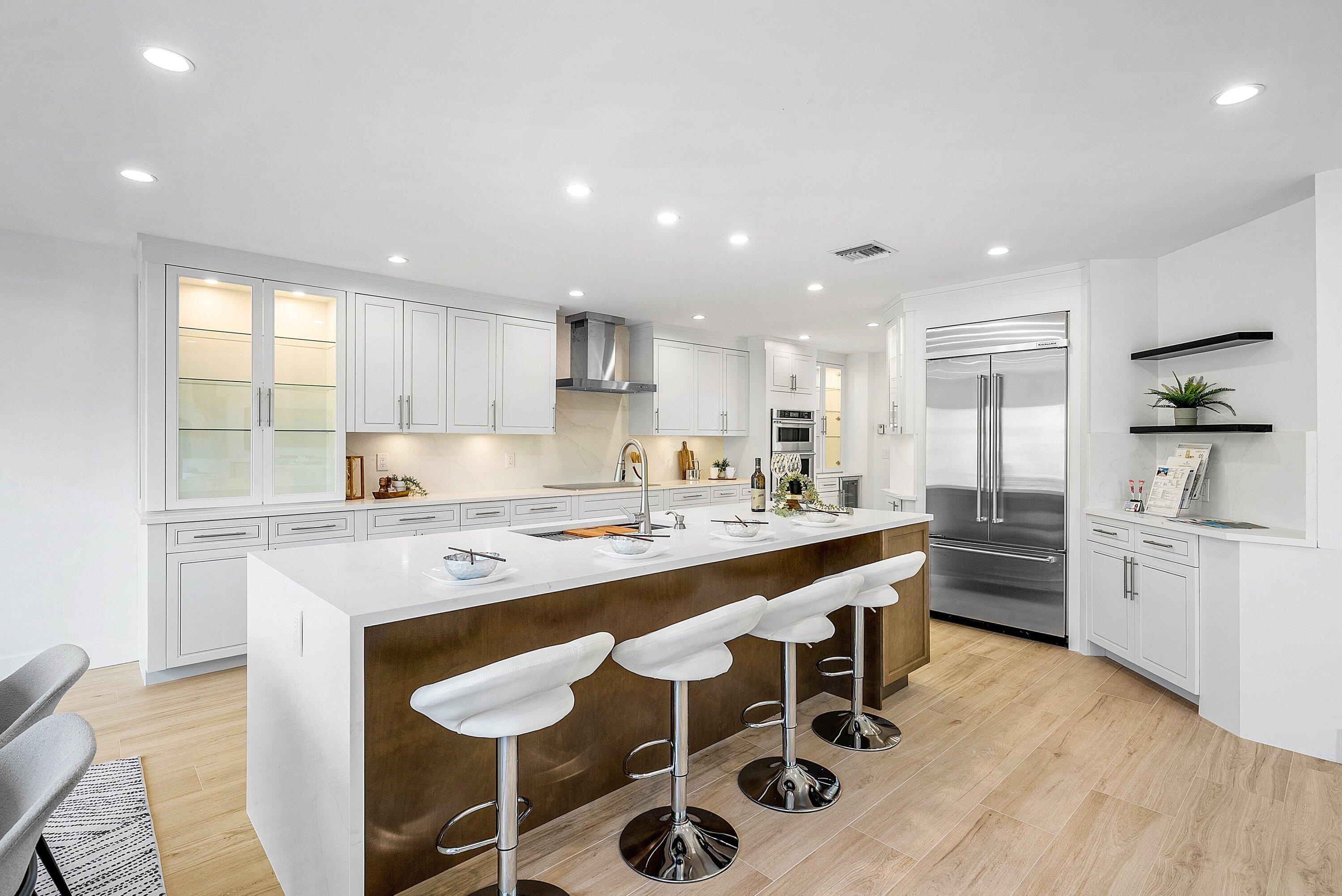 5174 Windsor Parke Drive Boca Raton, FL 33496 - Photo 3 of 55 a large kitchen with kitchen island a dining table chairs stainless steel appliances and cabinets