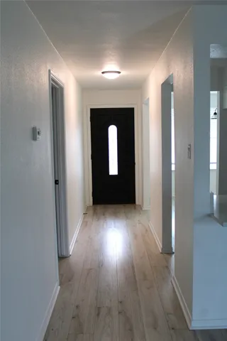 a view of a hallway with wooden floor