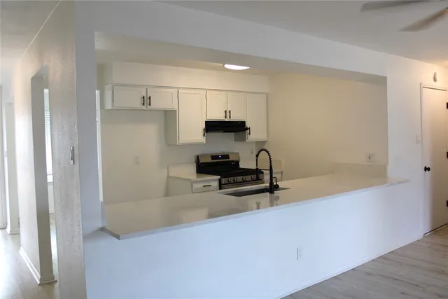 a kitchen with stainless steel appliances a refrigerator and a stove top oven