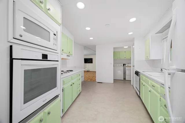 a view of a kitchen with lot of cabinets wooden floor and windows