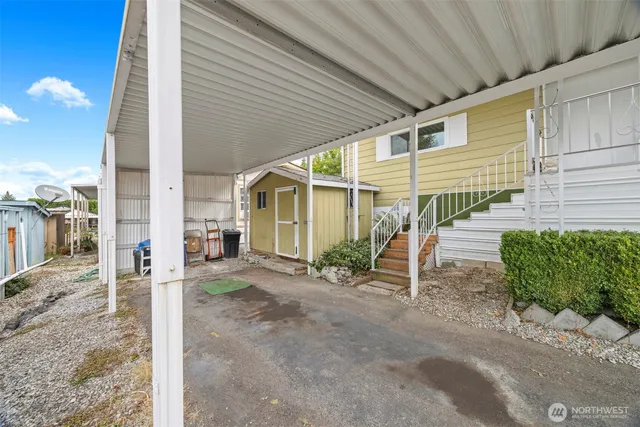 a porch with a table and chairs under an umbrella