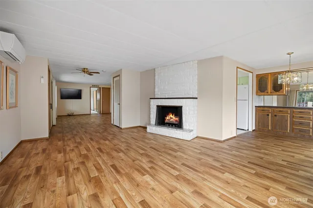 a view of empty room with wooden floor and fireplace