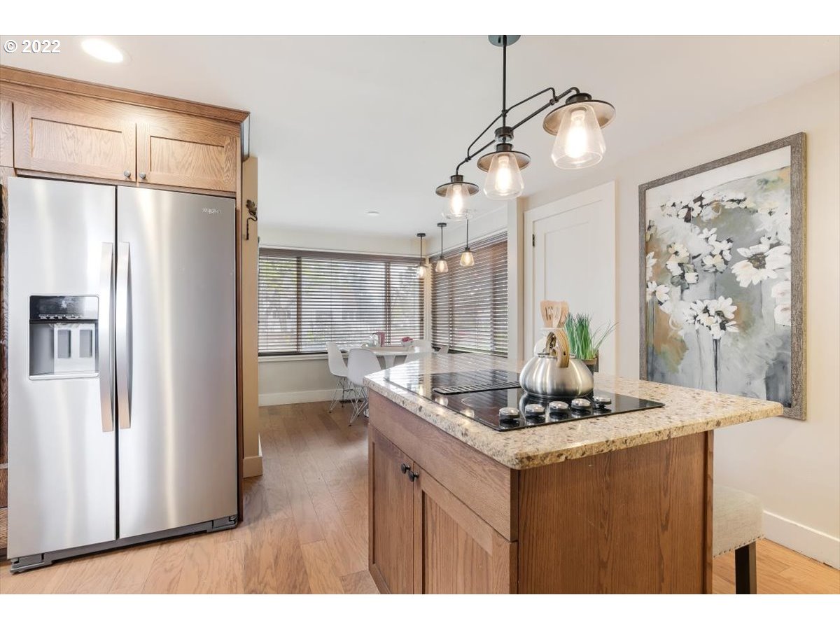 123 Shirley Street Molalla, OR 97038 - Photo 13 of 32 a kitchen with stainless steel appliances kitchen island granite countertop a refrigerator a stove and a refrigerator with wooden floor