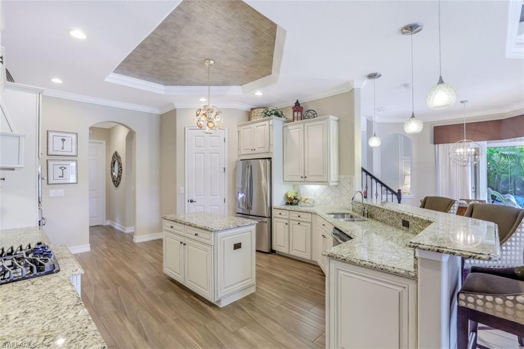 3289 Runaway Lane Naples, FL 34114 - Photo 12 of 35 a large kitchen with kitchen island a large counter space a sink stainless steel appliances and cabinets