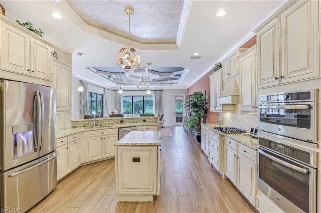3289 Runaway Lane Naples, FL 34114 - Photo 13 of 35 a large kitchen with stainless steel appliances lots of counter space and wooden floor