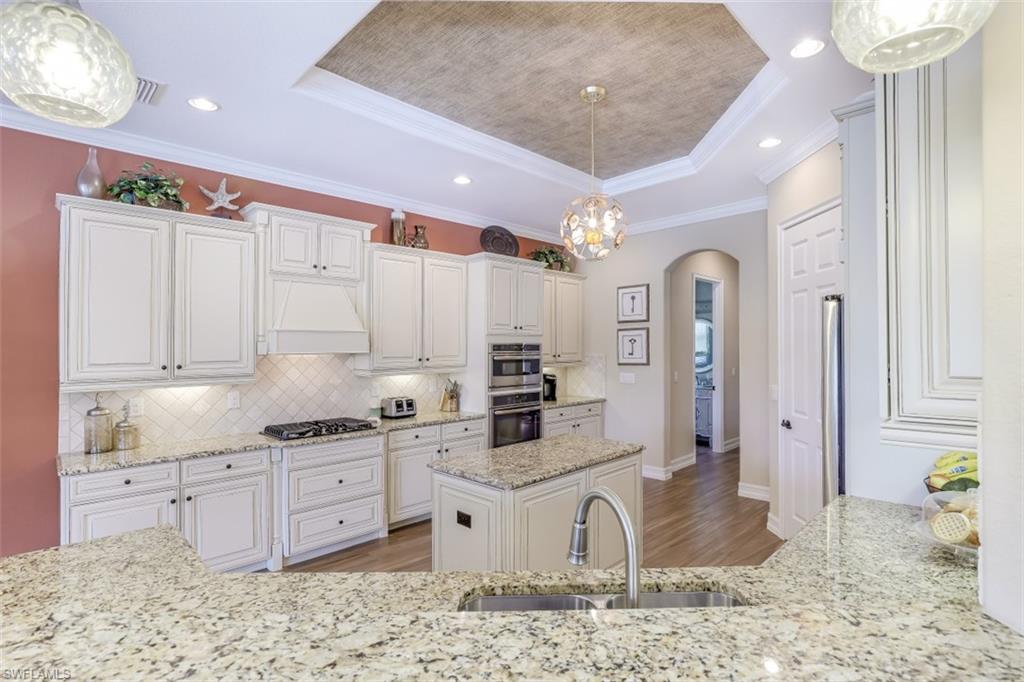 3289 Runaway Lane Naples, FL 34114 - Photo 14 of 35 a kitchen with stainless steel appliances kitchen island granite countertop a stove a sink and a refrigerator