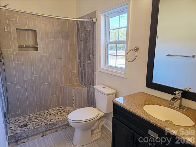 an empty room with windows and chandelier fan