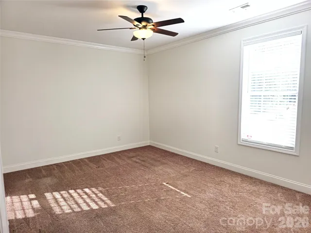 an empty room with wooden floor and window