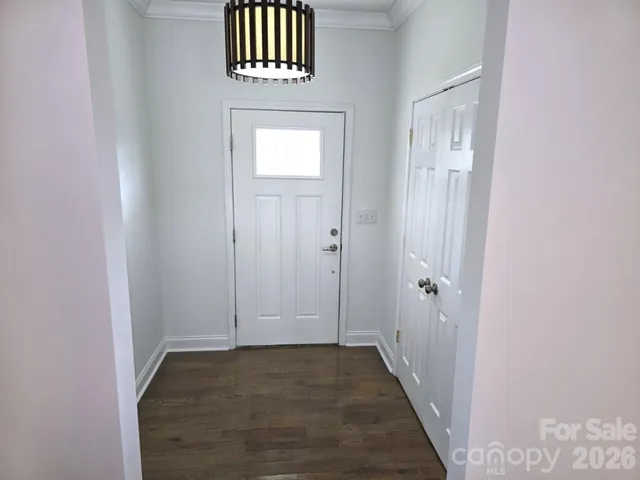 a view of kitchen with stainless steel appliances granite countertop a stove top oven a sink with wooden floors and white walls
