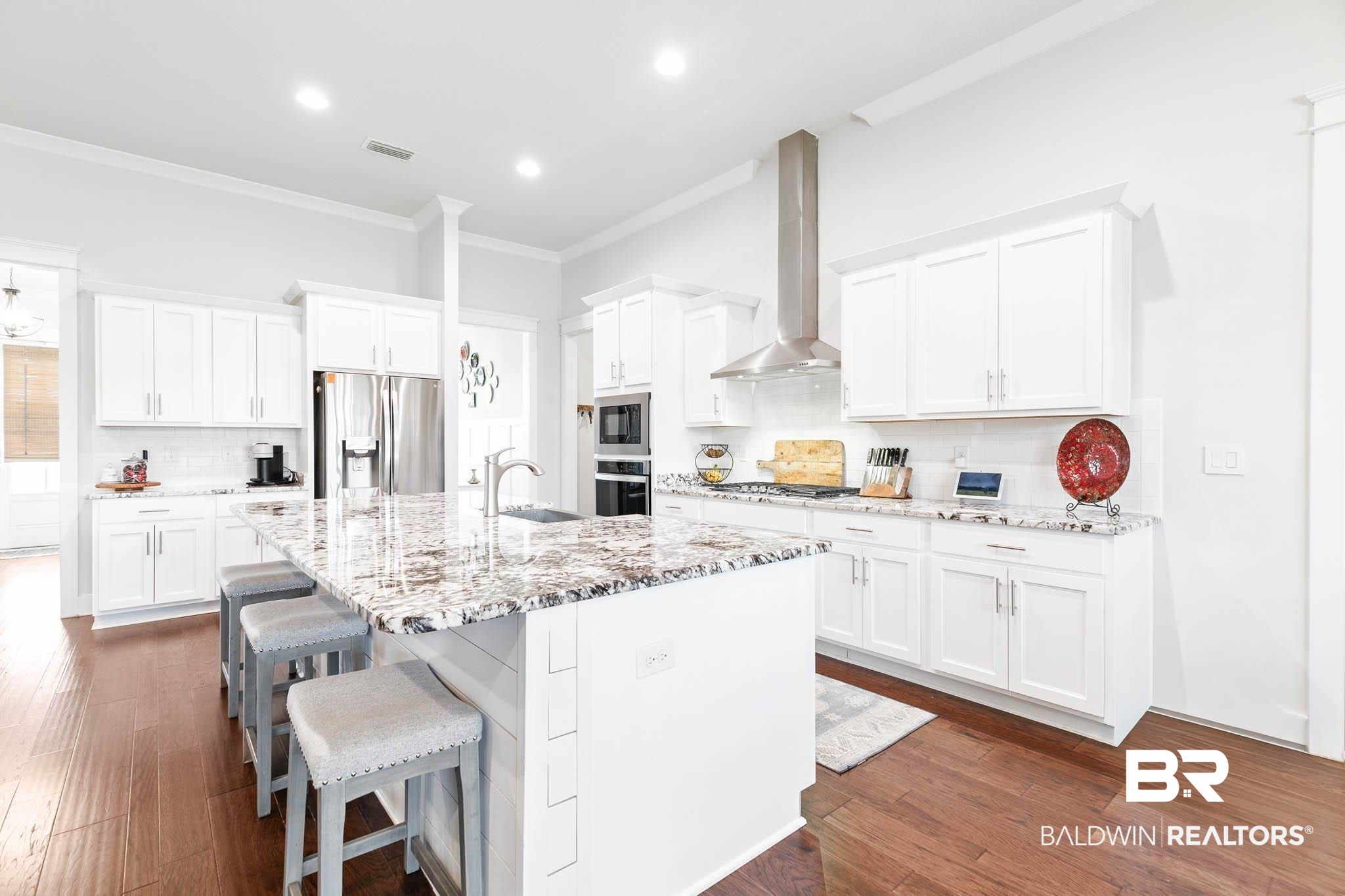 12785 Warbler Street Daphne, AL 36527 - Photo 13 of 53 Kitchen featuring tasteful backsplash, white cabinets, dark wood finished floors, light stone counters, and crown molding