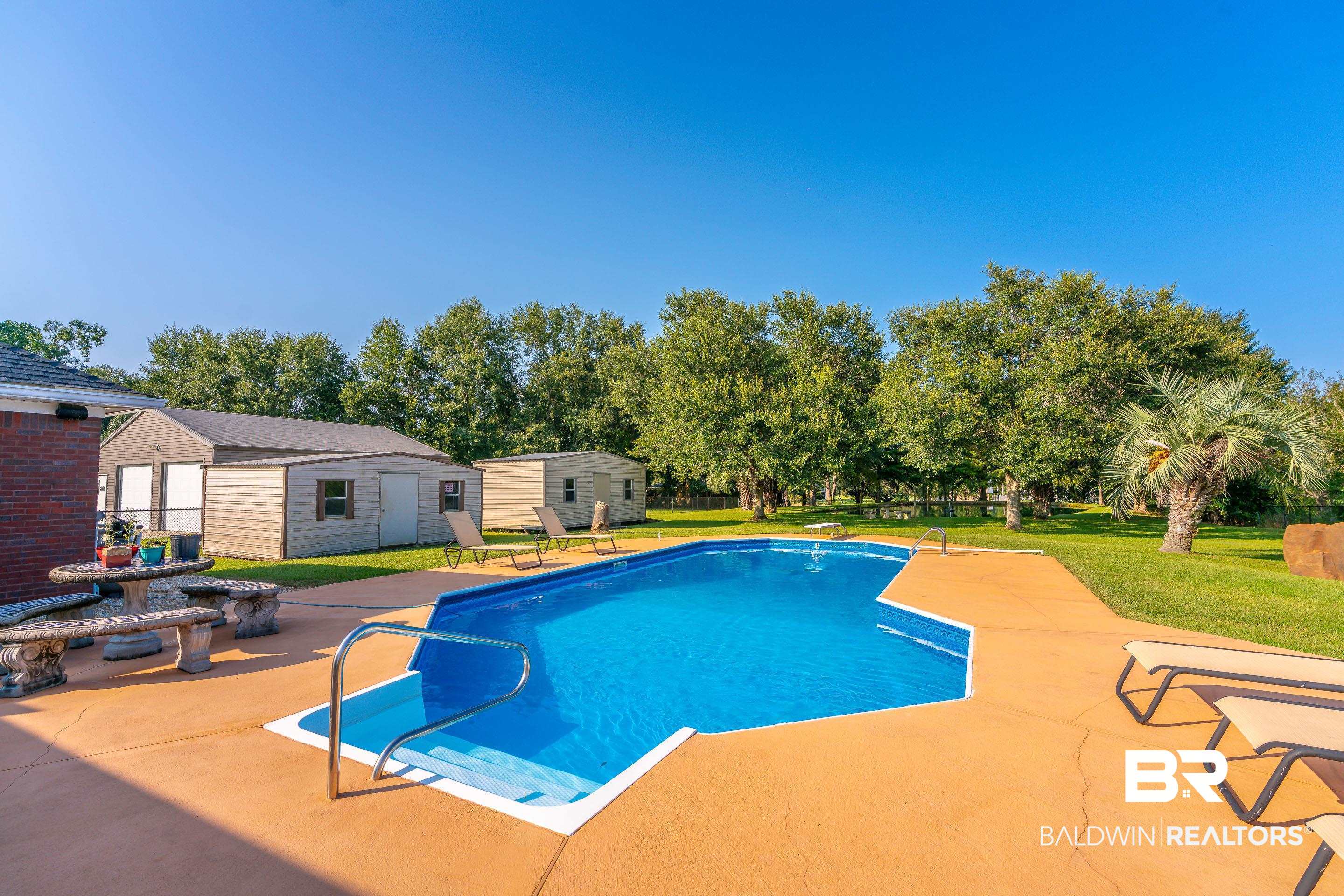 9477 Deerfield Drive Irvington, AL 36544 - Photo 47 of 58 View of swimming pool featuring a diving board, a patio, a yard, a shed, and a fire pit