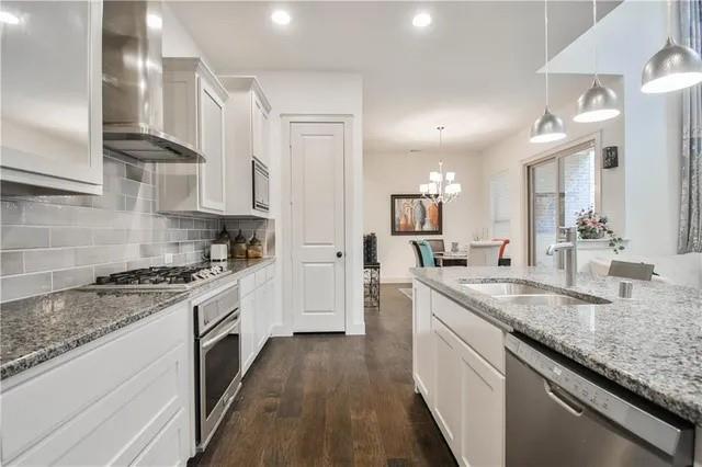 1402 French Violet Way Arlington, TX 76005 - Photo 26 of 29 a kitchen with granite countertop stainless steel appliances a sink stove top oven and cabinets
