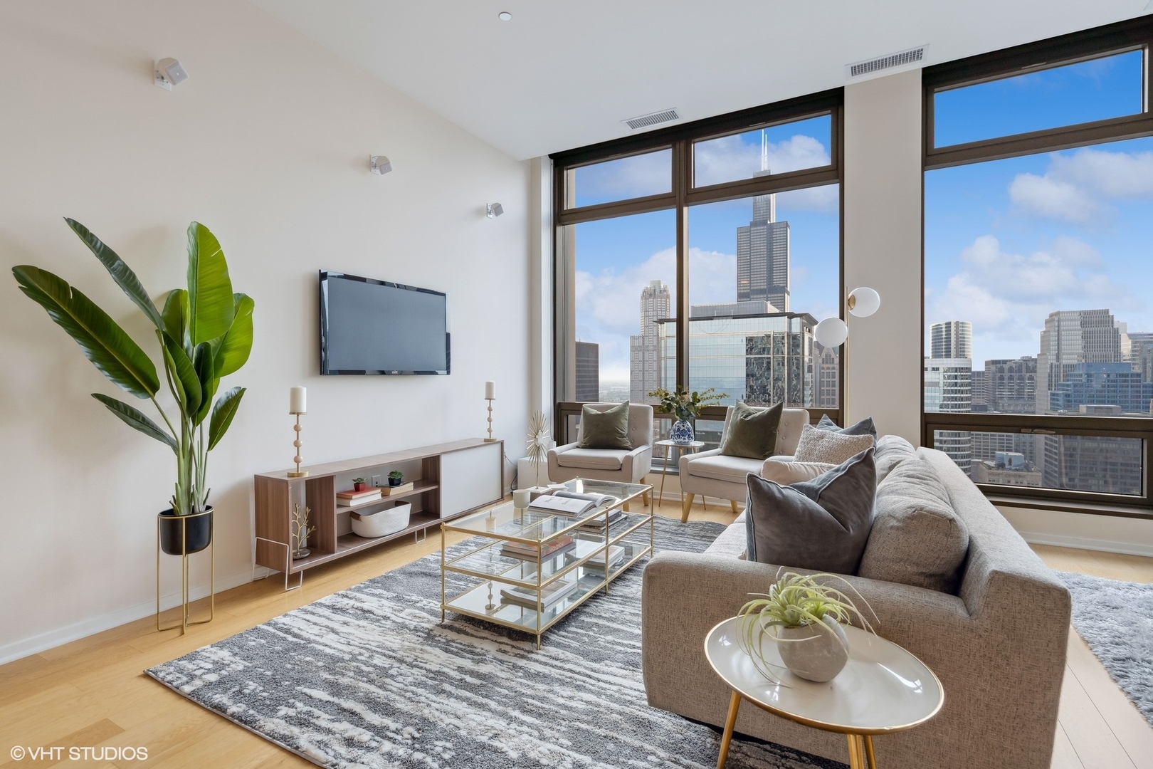 65 East Monroe Street, Unit 4217 Chicago, IL 60603 - Photo 3 of 27 a living room with furniture a large window and a flat screen tv