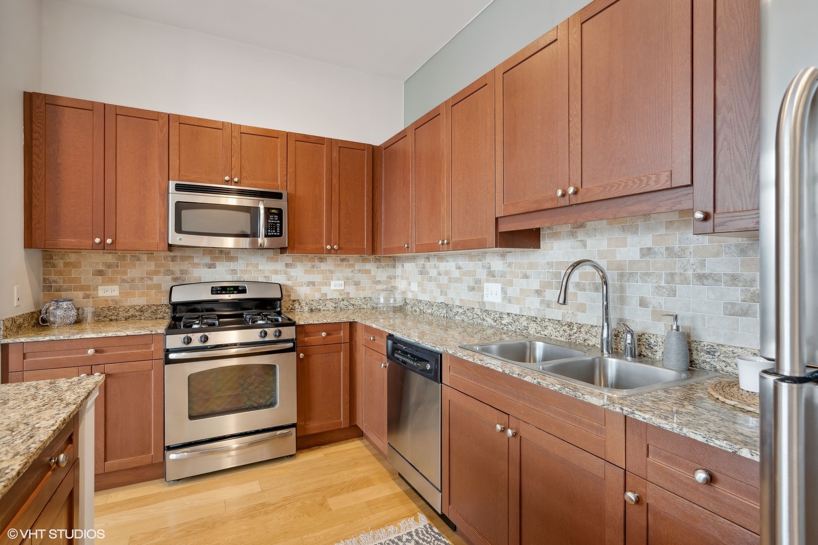 65 East Monroe Street, Unit 4217 Chicago, IL 60603 - Photo 8 of 27 a kitchen with stainless steel appliances granite countertop a sink stove and microwave