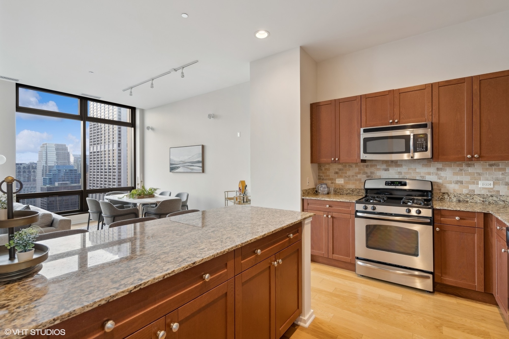 65 East Monroe Street, Unit 4217 Chicago, IL 60603 - Photo 9 of 27 a kitchen with stainless steel appliances granite countertop a stove a sink and a microwave