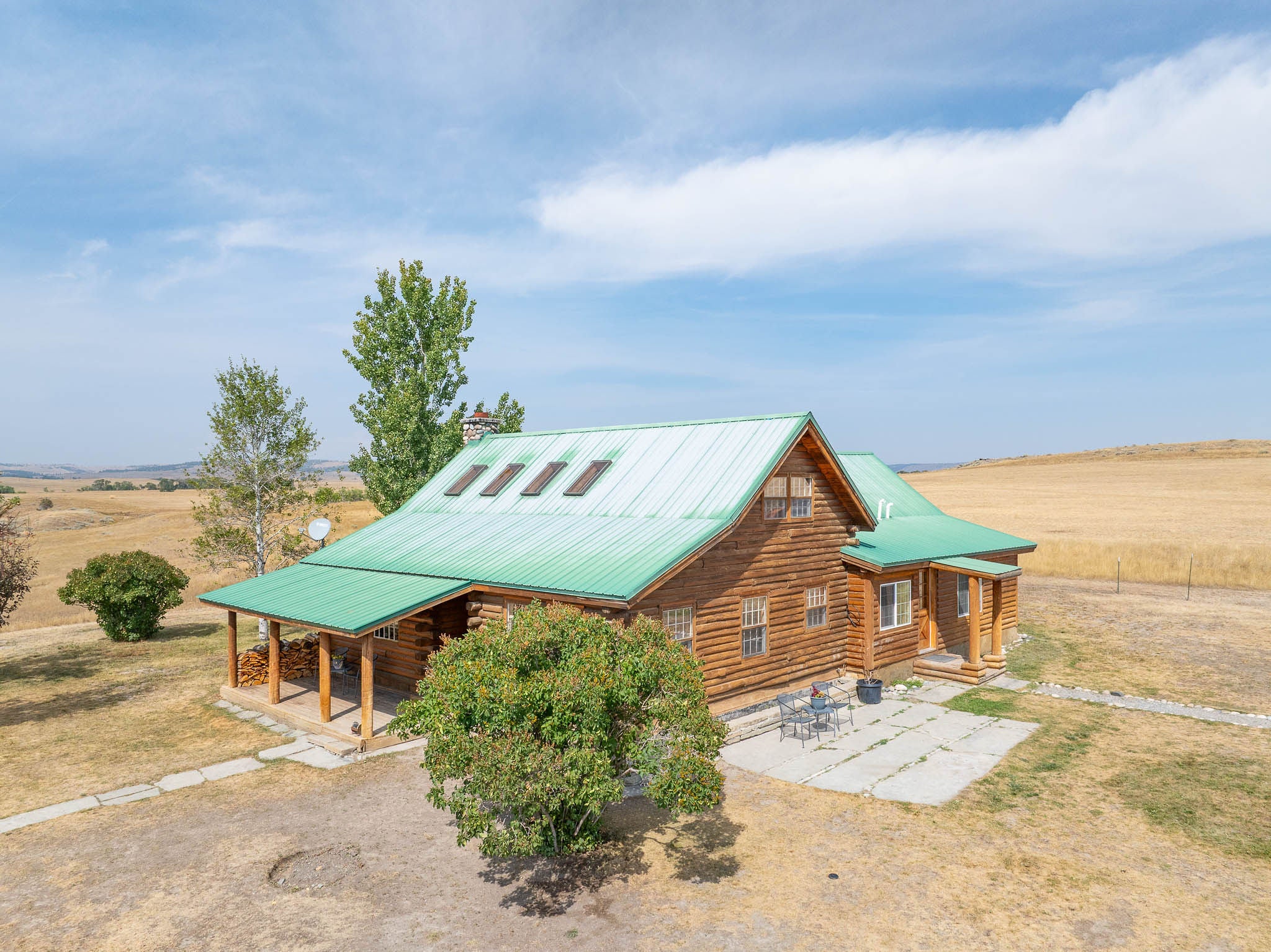 2 West Trees Road Reed Point, MT 59069 - Photo 1 of 1 Log-style house featuring log exterior, a metal roof, a view of countryside, and covered porch