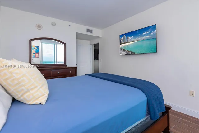 a bedroom with a bed and a flat screen tv