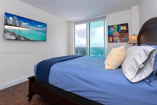 a bedroom with a bed and painting on the wall