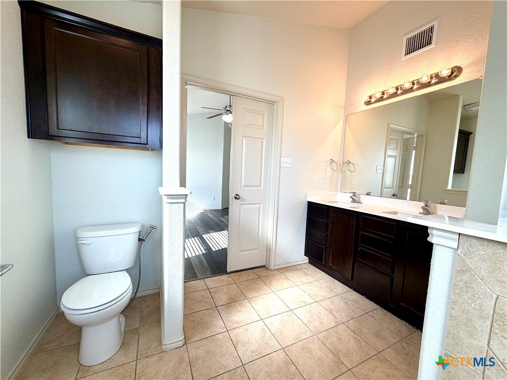 500 Obsidian Lane Jarrell, TX 76537 - Photo 24 of 33 a spacious bathroom with a toilet sink and mirror