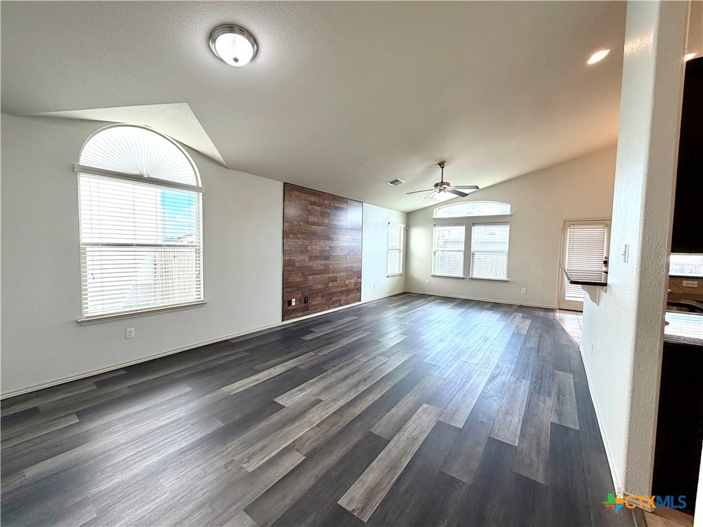 500 Obsidian Lane Jarrell, TX 76537 - Photo 7 of 33 an empty room with wooden floor and windows