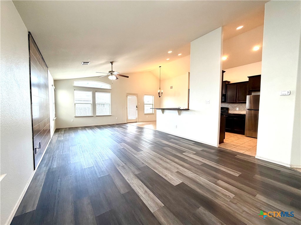 500 Obsidian Lane Jarrell, TX 76537 - Photo 8 of 33 a view of empty room with wooden floor and windows