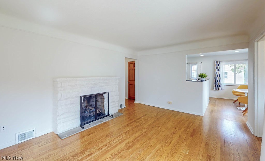 1200 Winston Road Cleveland, OH 44121 - Photo 6 of 35 Living room with hardwood floors and fireplace, with view into kitchen.