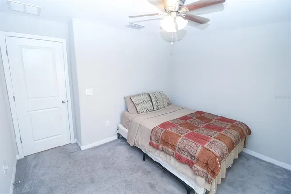 a bedroom with a bed and a ceiling fan