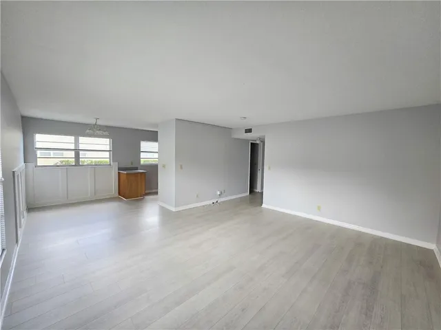 a view of empty room with wooden floor and windows