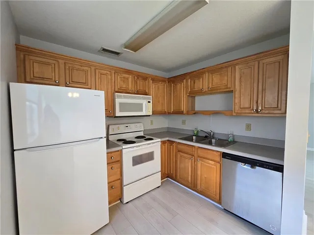 a kitchen with stainless steel appliances granite countertop a refrigerator stove a sink dishwasher and a microwave