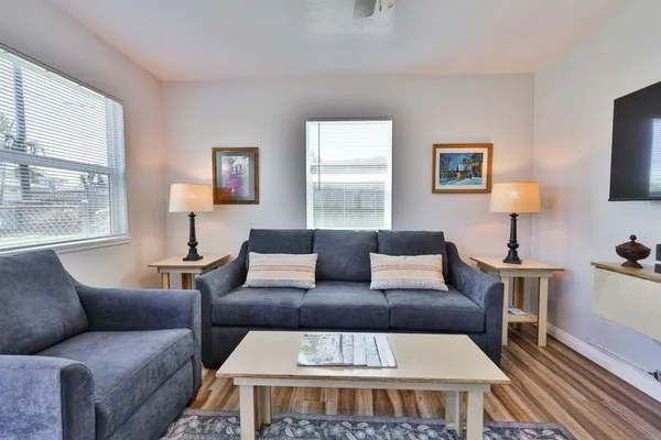 a living room with furniture a large window and a rug