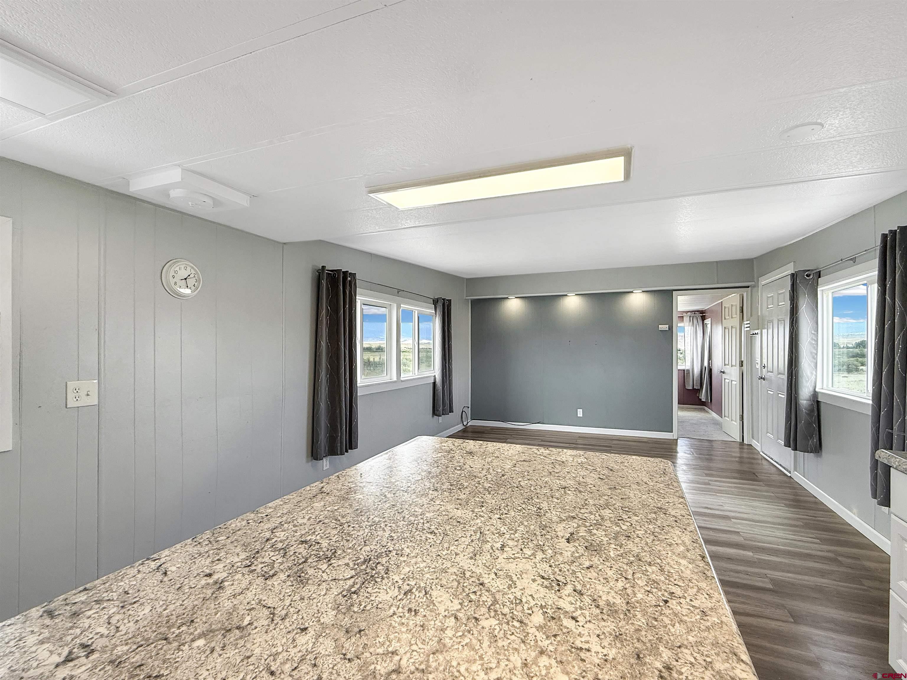 5057 Peach Valley Road Delta, CO 81416 - Photo 11 of 22 a view of a big room with wooden floor and windows