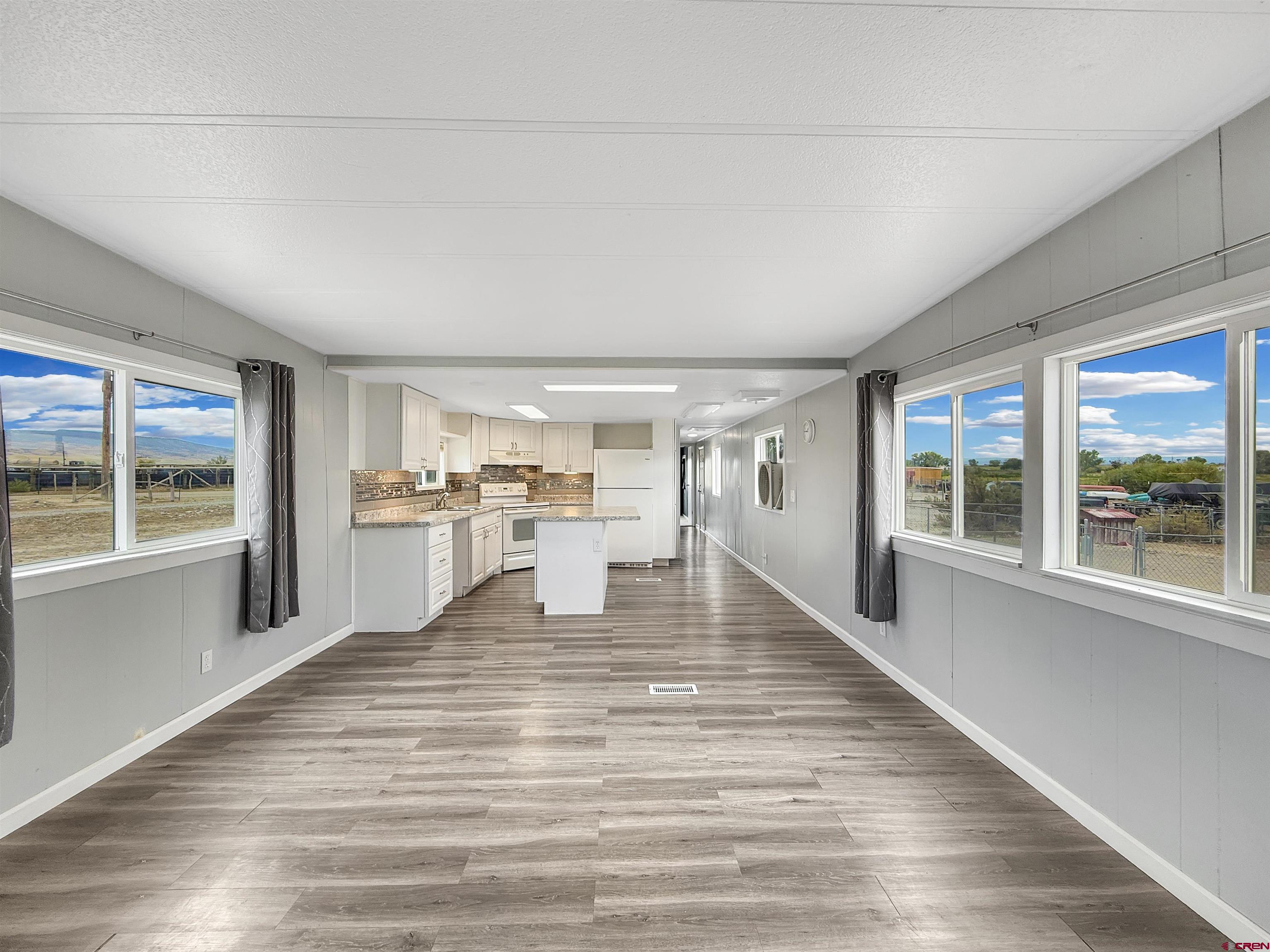 5057 Peach Valley Road Delta, CO 81416 - Photo 8 of 22 a view of open kitchen with wooden floor and white appliances