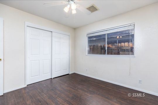 613 South Silver Ridge Street Ridgecrest, CA 93555 - Photo 16 of 26 an empty room with wooden floor and windows