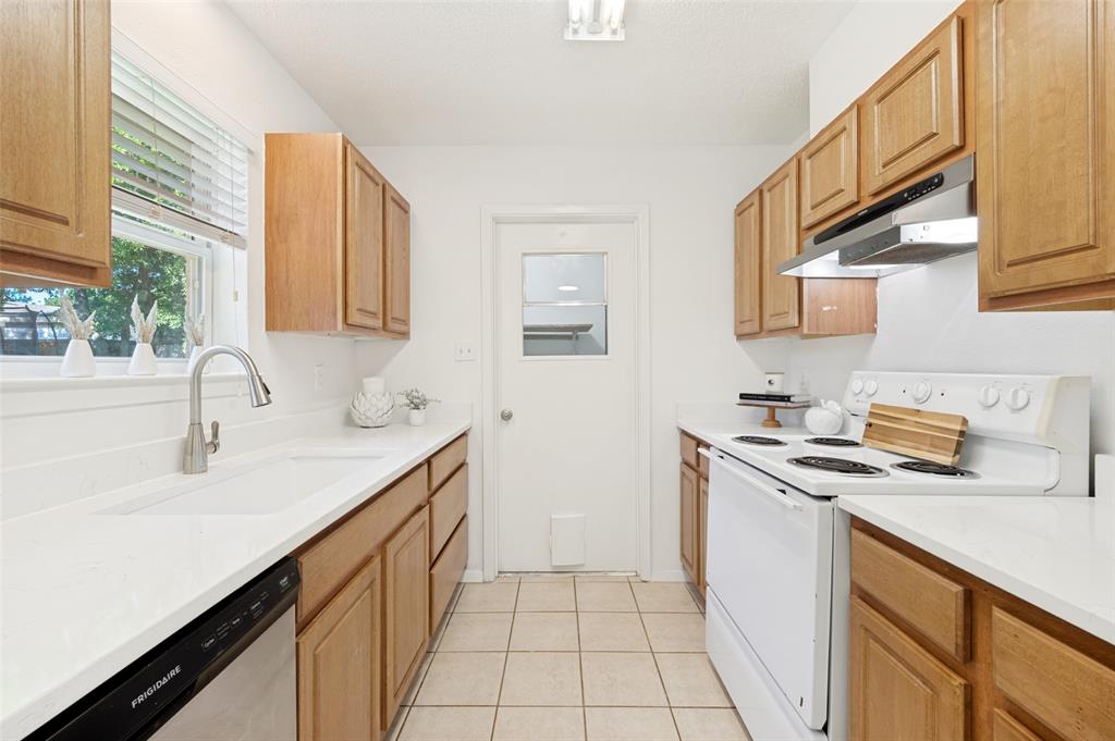 709 East Main Street Pilot Point, TX 76258 - Photo 5 of 11 a kitchen with stainless steel appliances granite countertop a sink stove and cabinets