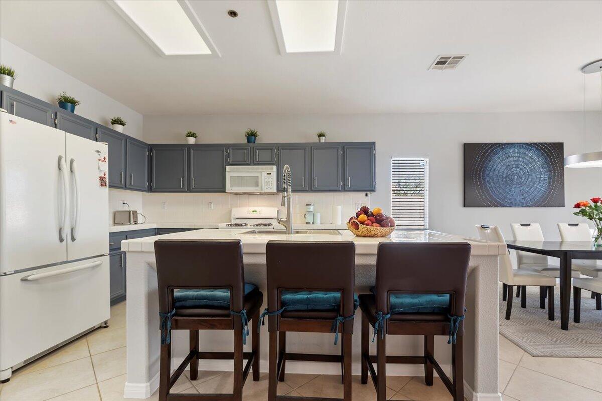 3982 Eastgate N Road Palm Springs, CA 92262 - Photo 13 of 55 a kitchen with stainless steel appliances a table chairs and a refrigerator