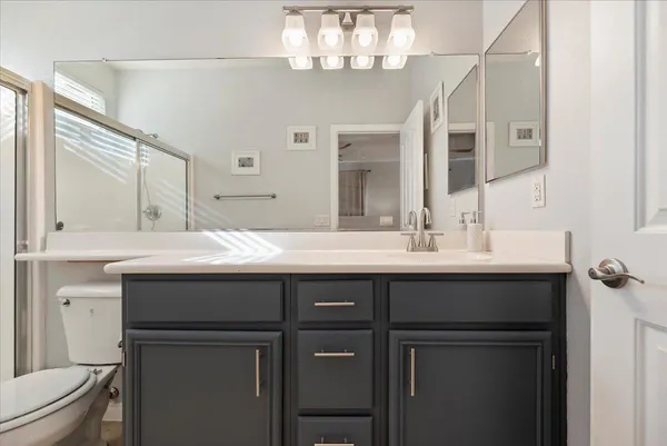 a bathroom with a sink a toilet and shower