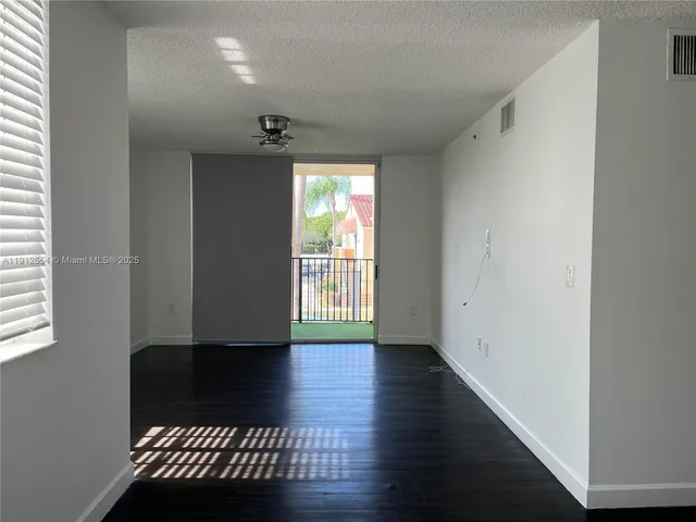 a view of a hallway with wooden floor and a window