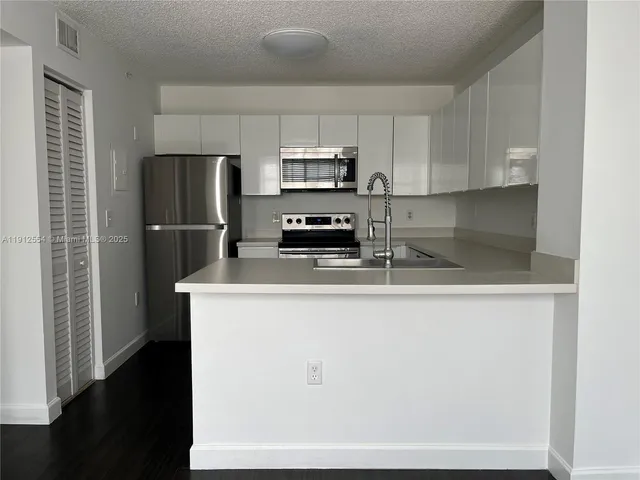 a kitchen with stainless steel appliances a refrigerator a stove a microwave and cabinets